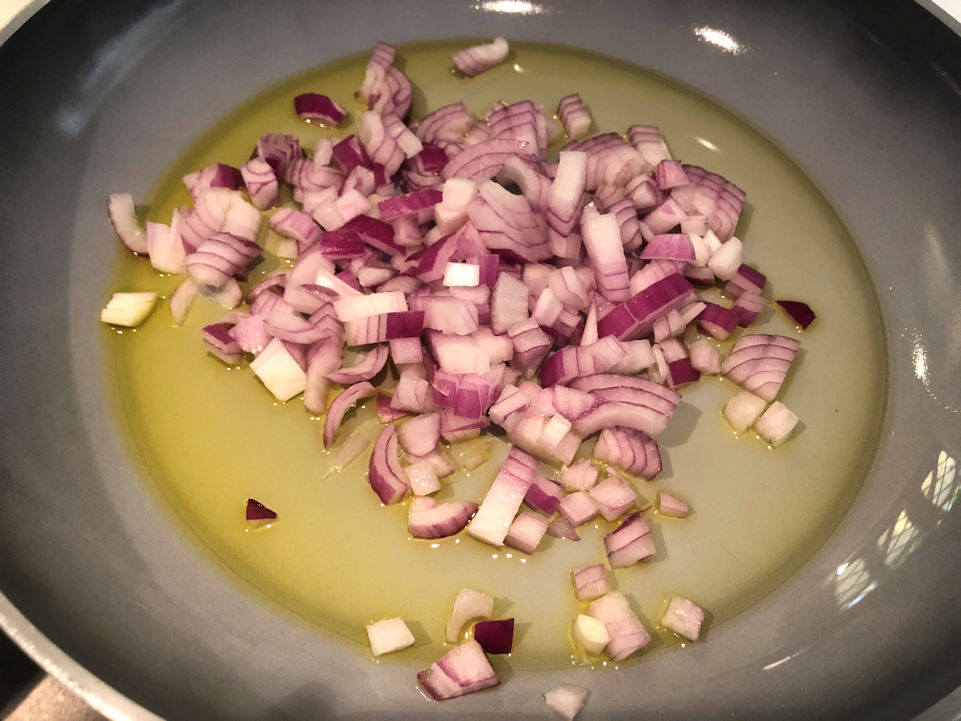 Padella, olio e cipolla a cubetti